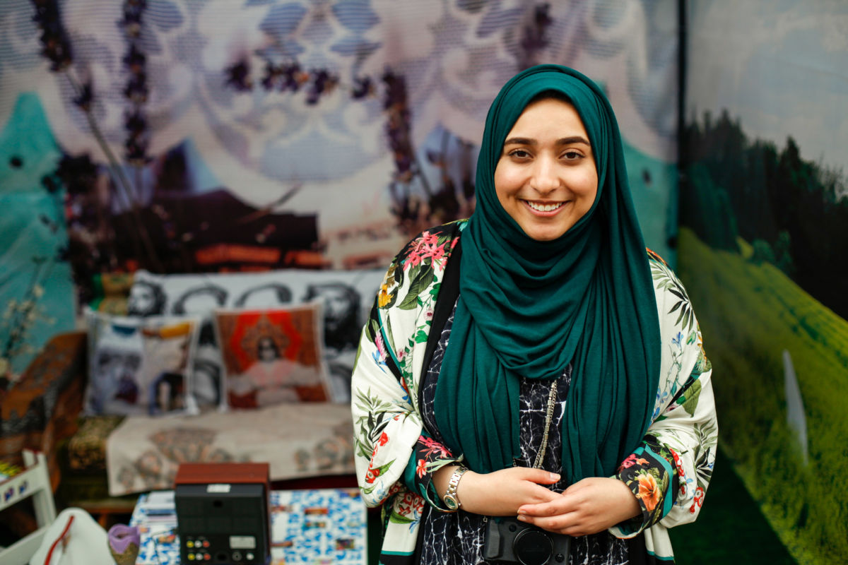 woman in head scarf in front of a colourful display