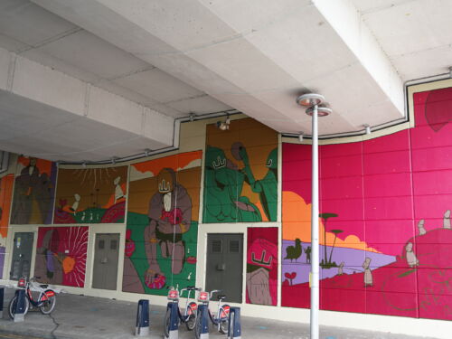 A brightly coloured mural situated on the wall of an underpass in North Kensington. It depicts creatures settling, leaving and searching for new homes under the watchful eyes of an ominous figure.