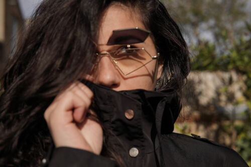 A picture of a woman with dark hair wearing glasses and a black top