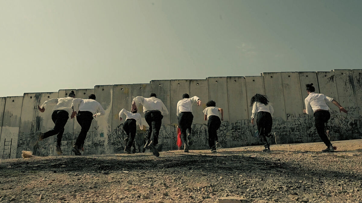 Line of dancers run towards a wall