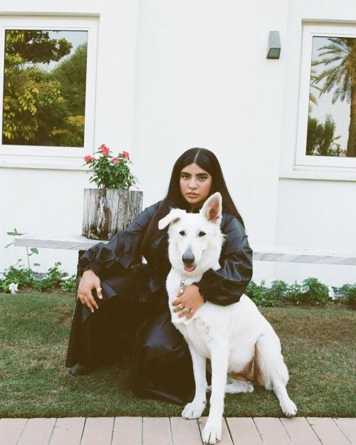 Woman in black holds white dog