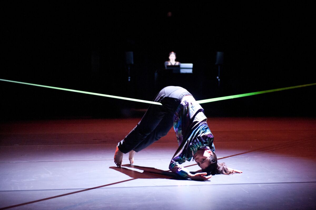 Image of performer bending over a rope.