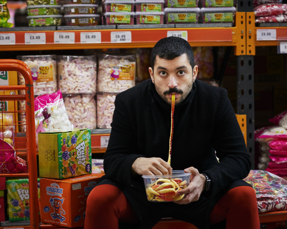 Image of Hamed Sinno eating a jelly snake in a supermarket