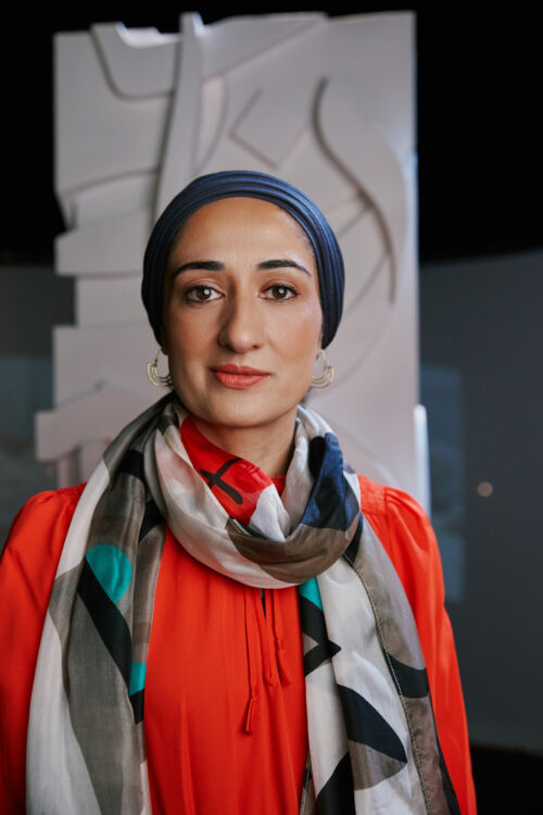 Portrait of Soraya Syed standing in front of artwork