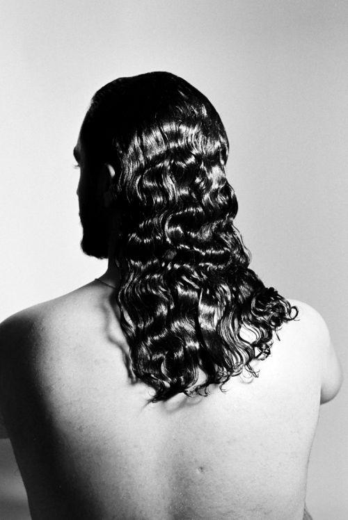Black and white photo of a person with long, wavy hair cascading down their back. The smooth, shiny waves create a sense of elegance and calm.